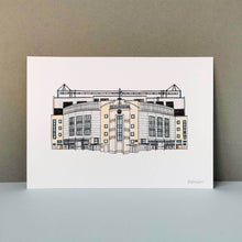 Load image into Gallery viewer, A Chelsea Stadium Print. The piece is a detailed illustration of Stamford Bridge in fineliner and watercolours. Printed on thick paper, photographed against a grey background.

