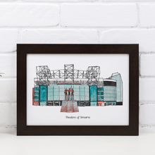 Load image into Gallery viewer, A personalised Manchester United football print of the stadium, it has the words 'Theatre of Dreams' printed below the print and is in a black frame, photographed against a white brick wall.