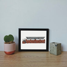 Load image into Gallery viewer, Jessica Sian Illustration&#39;s Fulham Football ground print in a black frame against a light blue wall with a succulent to the side.
