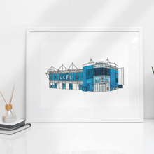 Load image into Gallery viewer, A detailed illustration of the King Power Stadium, home to Leicester City FC. The print is in a white frame propped against a white wall. 

