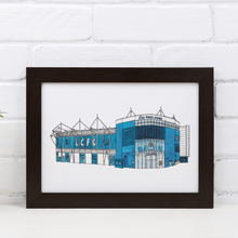 Load image into Gallery viewer, A Leicester City wall art print of the King Power Stadium. The piece is a full colour print of the front of the football ground. It&#39;s framed in a black frame and signed by the artist, Jessica Sian.
