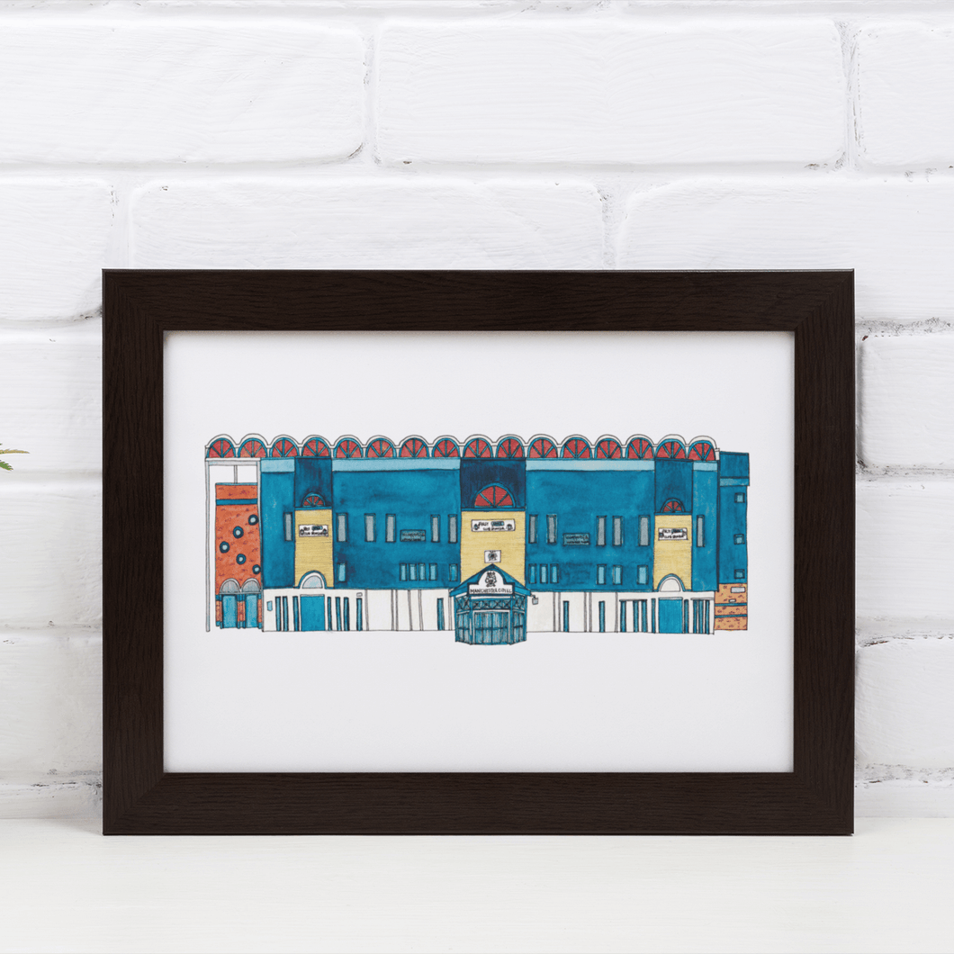 A detailed painting of Manchester City's Maine Road football stadium. The piece is in a black frame against a white brick wall.