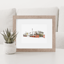 Load image into Gallery viewer, A framed illustration of Meadow Lane, the football ground home to Notts County. The piece is in a wooden frame, sat on a coffee table next to a small succulent. 
