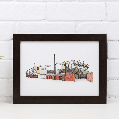 A detailed print of Notts County Stadium, Meadow Lane. The design is printed from Jessica Sian's original hand drawn artwork of the football ground. Framed in a black frame, propped against a white brick wall.