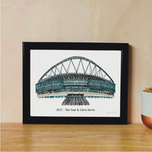 Load image into Gallery viewer, A hand-drawn print of Wembley Stadium, where England&#39;s Women&#39;s Football team won the 2022 Euros. It has the text &#39;2022 - The Year It Came Home&#39; underneath the print. The piece is in a black frame.
