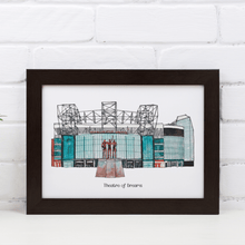 Load image into Gallery viewer, A personalised Manchester United football print of the stadium, it has the words &#39;Theatre of Dreams&#39; printed below the print and is in a black frame, photographed against a white brick wall.
